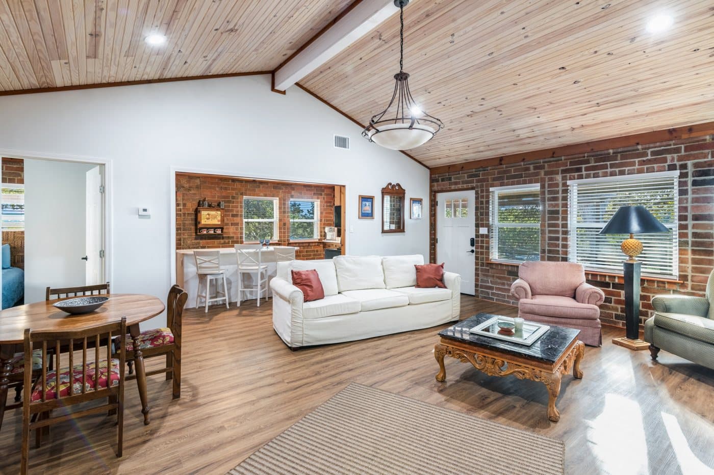 Canyon Lake great room with raised wood ceilings and exposed brick